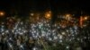 Los manifestantes iluminan con sus teléfonos móviles las cercanías del Palacio de Justicia Federal en la ciudad estadounidense de Portland, Oregon, en donde han estado protestando por dos meses contra el racismo y la violencia policial.