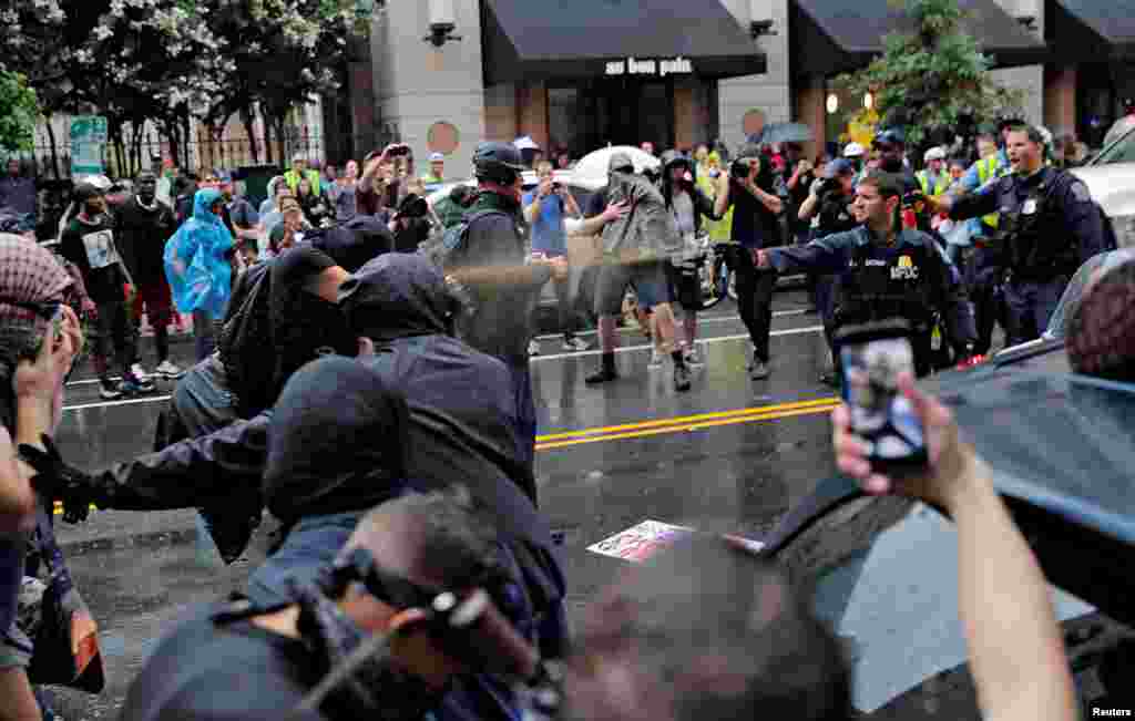 Police officers use pepper spray towards counter-demonstrators during a white nationalist-led rally marking the one year anniversary of the 2017 Charlottesville ‘Unite the Right’ protests, in Washington, Aug. 12, 2018.