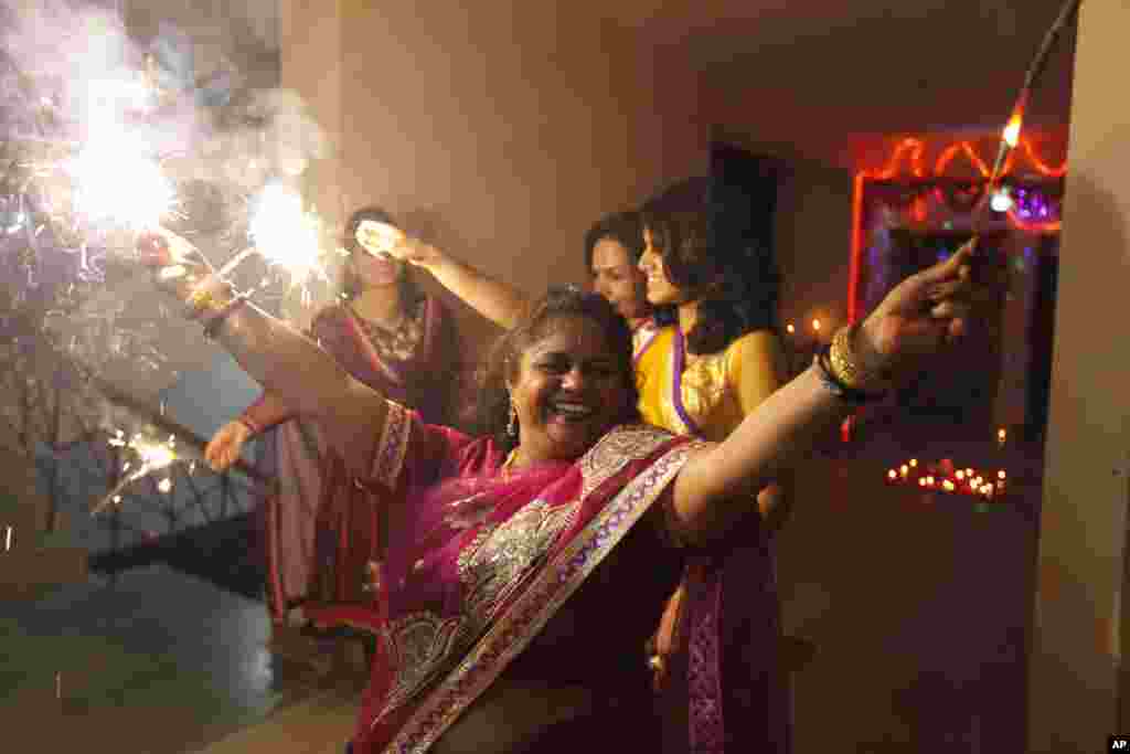 Indian Hindu women play with fireworks to celebrate Diwali, Allahabad, India, Nov. 3, 2013.