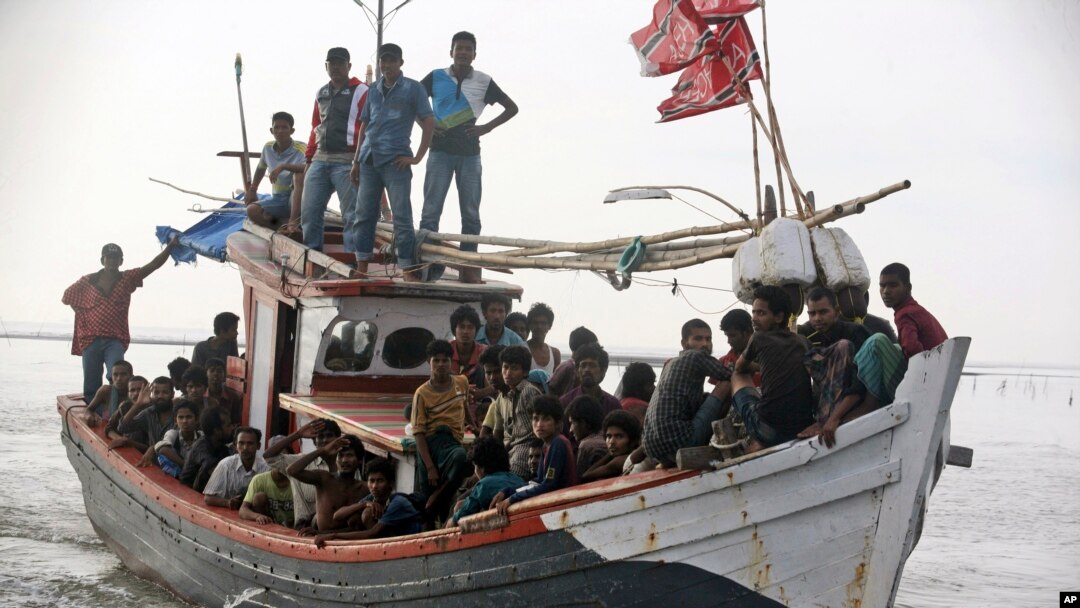 An Acehnese fishing boat full of rescued migrants approaches to dock in Simpang Tiga, Aceh province, Indonesia, Wednesday, May 20, 2015. Hundreds of migrants stranded at sea for months were rescued and taken to Indonesia, officials said Wednesday, the lat