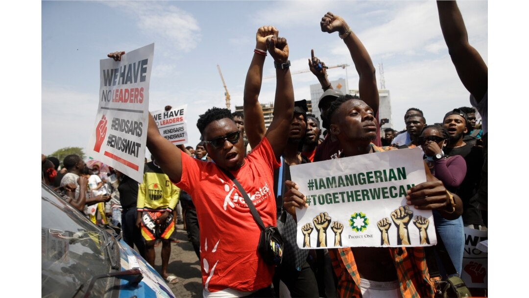 People hold banners as they demonstrate on the street to protest against police brutality in Lagos, Nigeria, Oct. 15, 2020.