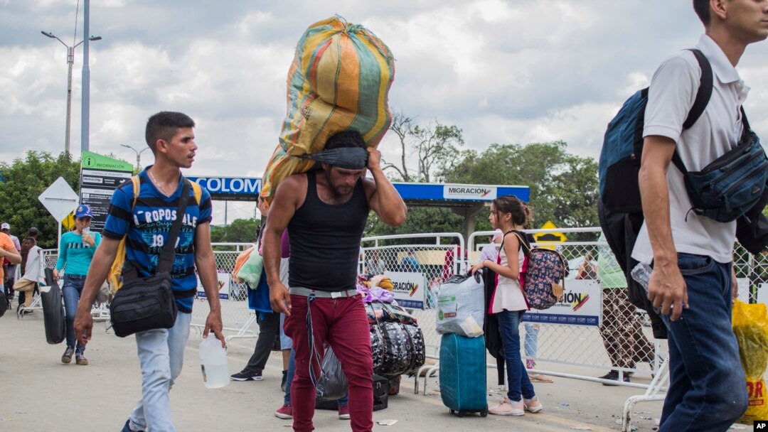 A man carries a large load on his back, with the strap around his forehead, as he works as a “lomo taxista,” or taxi of the lower back, across the border from Cucuta, Colombia to Venezuela, Sept. 20, 2019.