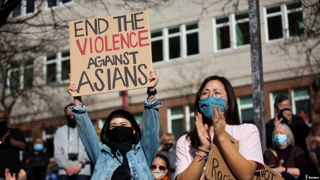  Dawn Cheung and Victoria Do clap and cheer while listening to speakers during a protest against anti-Asian hate crimes at Hing Hay Park in the Chinatown-International District of Seattle, Washington, March 13, 2021. 