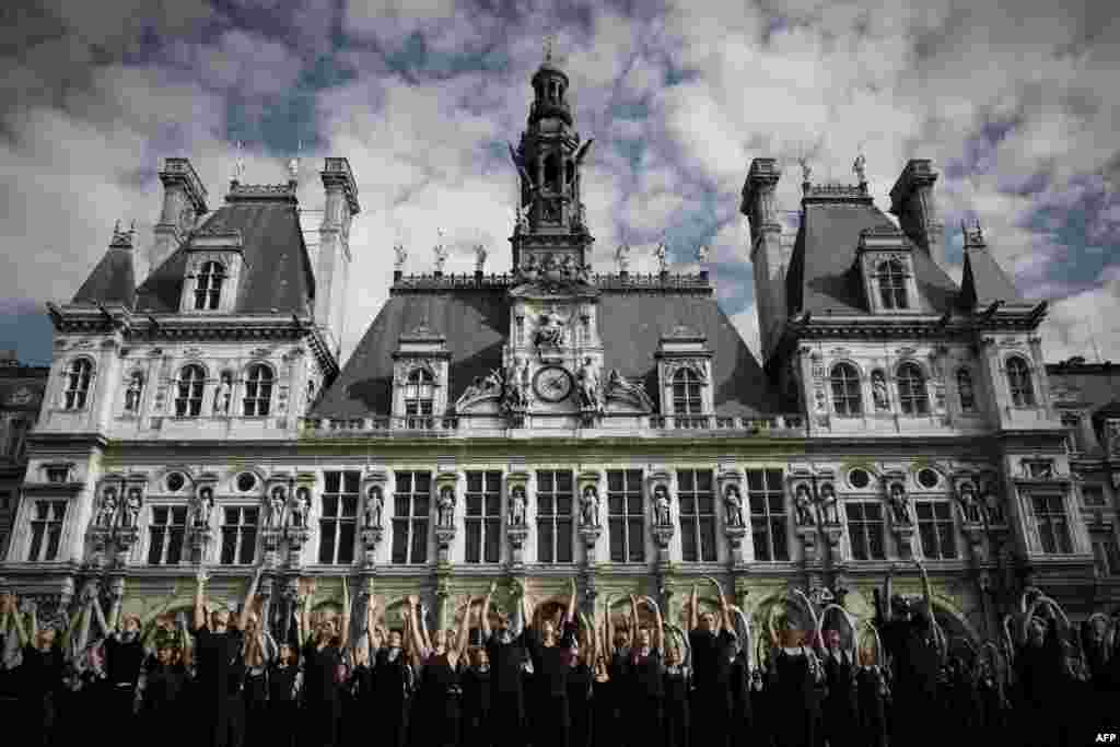 Dancers perform during an outdoor mass performance created by choreographer Akram Khan titled "Kadamati" in front of the city hall in Paris, France.