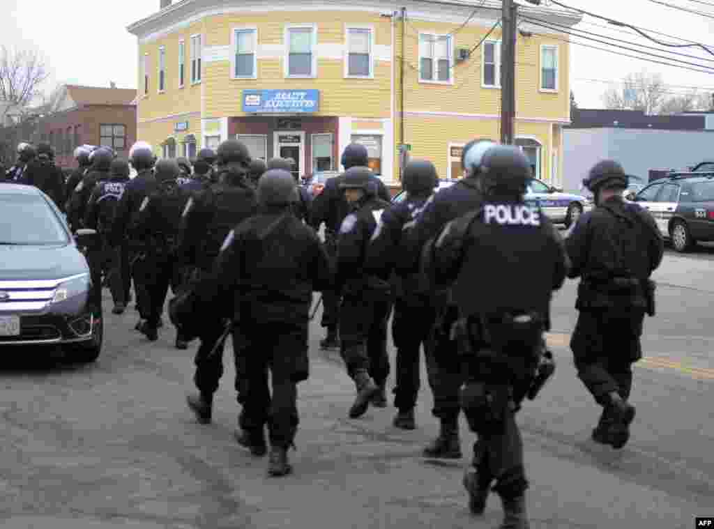 Police walk down School and Walnut Street on April 19, 2013 in Watertown.