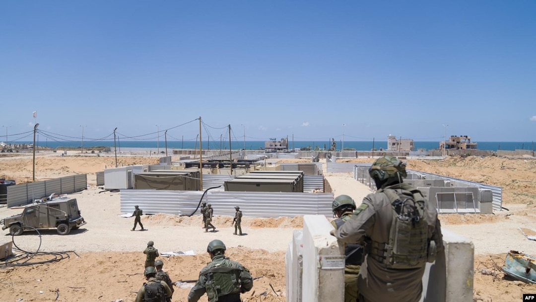 In this picture released by the Israeli army on May 16, 2024, Israeli troops work to connect a U.S.-built floating pier to the shore. The new entry point will allow more humanitarian aid to enter the Gaza Strip.