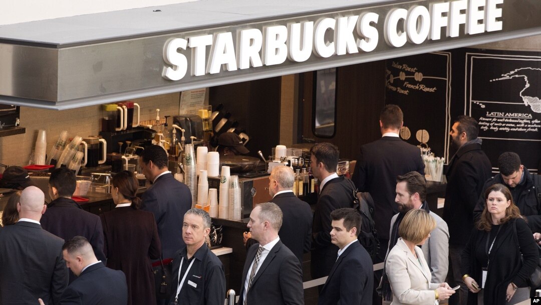 FILE - Customers line up at a Starbucks in New York, April 2, 2015. 