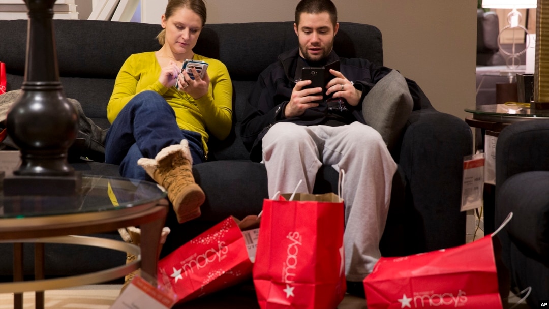 Andrea and Karl Galvez of Chicago take a break from shopping during Black Friday shopping at Macy's on Nov. 29, 2013, in Chicago.