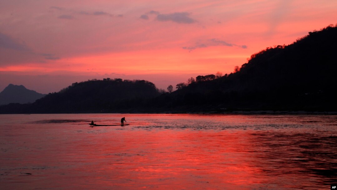 In this March 4, 2011, file photo, men ride in a boat across the Mekong River in Luang Prabang, Laos. It is officially described as the best-preserved city in Southeast Asia, a bygone seat of kings tucked into a remote river valley of Laos. Luang Prabang 