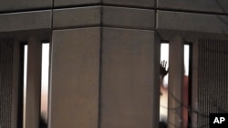 Un prisionero muestra su mano por una ventana de la prisión del condado de Pierce, en el estado de Washington, mientras frente a la cárcel pasaba una marcha contra el maltrato policial en Estados Unidos. 