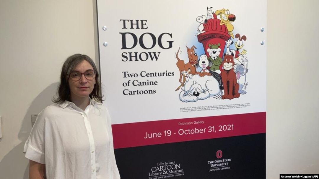 Anne Drozd, museum coordinator at Ohio State University's Billy Ireland Cartoon Library Museum, stands at the entrance to the library's new exhibit, "The Dog Show," on Thursday, June 24, 2021, in Columbus, Ohio(AP Photo/Andrew Welsh-Huggins)