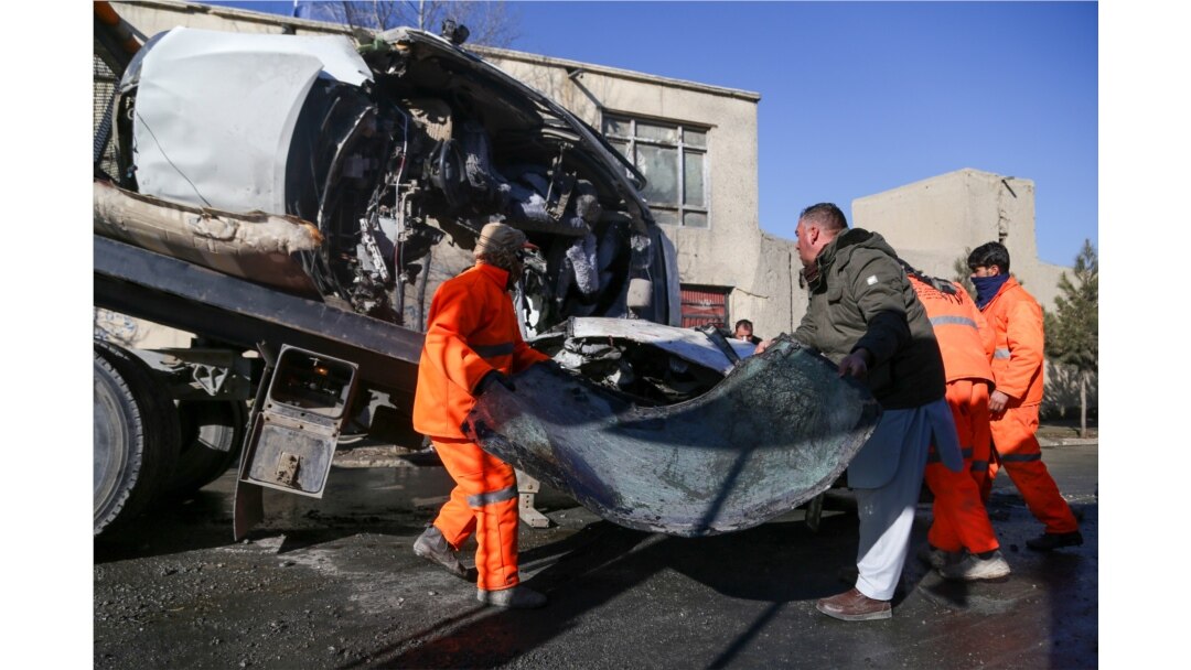 Municipal workers clean up debris at the site of a bomb attack in Kabul, Dec. 22, 2020.