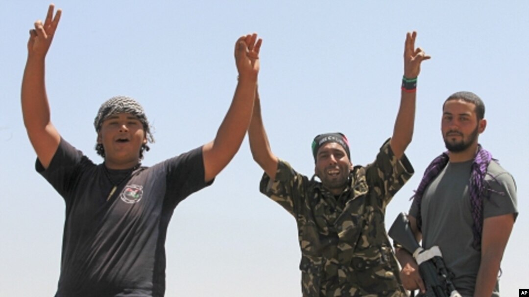 Libyan rebel fighters celebrate as they drive into the coastal city of Zawiyah, August 15, 2011.