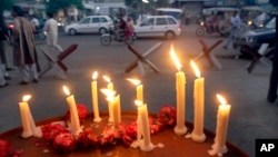 FILE - Lighted candles are seen outside a mosque of the Ahmadi sect, in Lahore, Pakistan, May 30, 2010. Unknown gunmen in central Pakistan on Thursday killed Malik Saleem Latif, a local leader of the Ahmadi community, considered the country’s most persecuted religious sect.