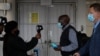 FILE - Passengers have their temperatures taken at the International O.R. Tambo Airport in Johannesburg, Oct. 1, 2020.
