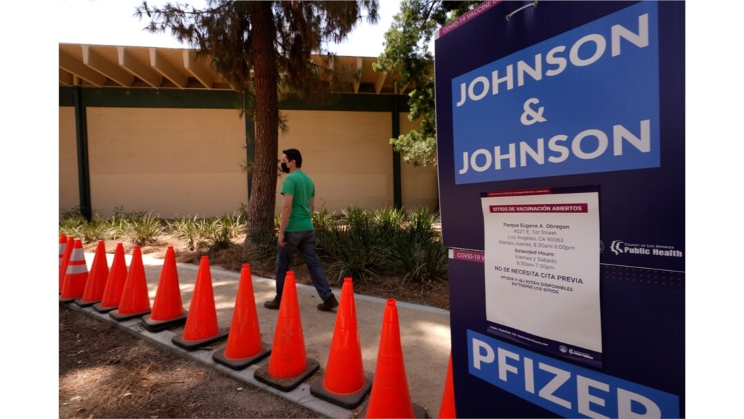 FILE - Carlos Arrendondo arrives for his appointment to get vaccinated, as banners advertise the availability of the Johnson & Johnson and Pfizer COVID-19 vaccines at Eugene A. Obregon Park in Los Angeles, July 22, 2021.