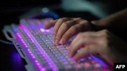 ARCHIVO - Un miembro de un grupo de piratas informáticos usa su computadora en la oficina del grupo en Dongguan, China, el 4 de agosto de 2020. 