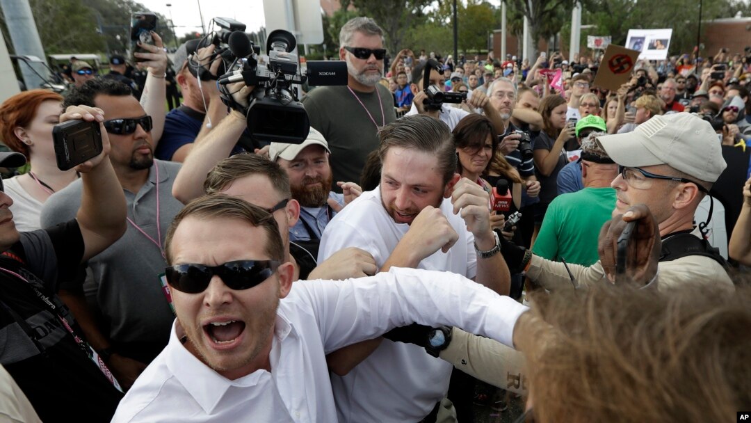 Two supporters of white nationalist Richard Spencer clash with a crowd of protesters after Spencer spoke at the University of Florida in Gainesville, Oct. 19, 2017. 