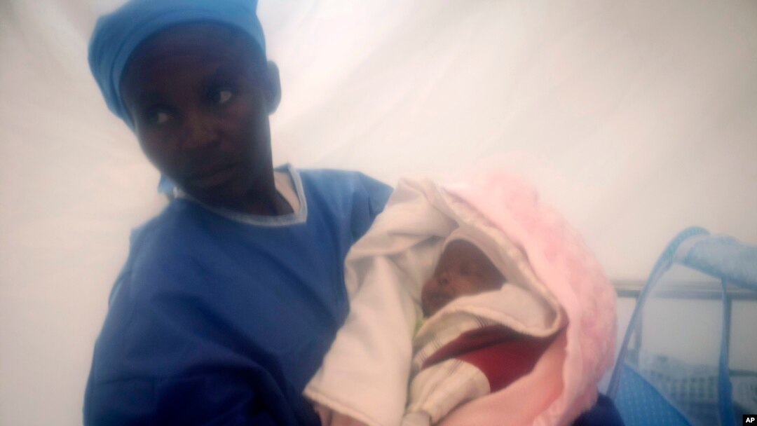 FILE - In this photograph taken Dec. 3, 2018, and released by UNICEF, an Ebola survivor cares for one-week-old Benedicte who was infected at birth with the Ebola virus by her mother, at an Ebola treatment center in Beni, Democratic Republic of the Congo. 