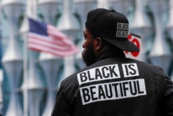 FILE - A protester stands in front of the US embassy during the Black Lives Matter protest rally in London, June 7, 2020.